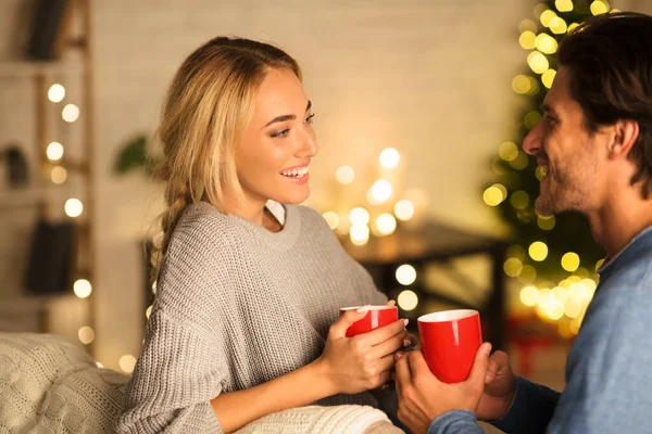 Liebespaar trinkt Tee vor dem Weihnachtsbaum — Stockfoto