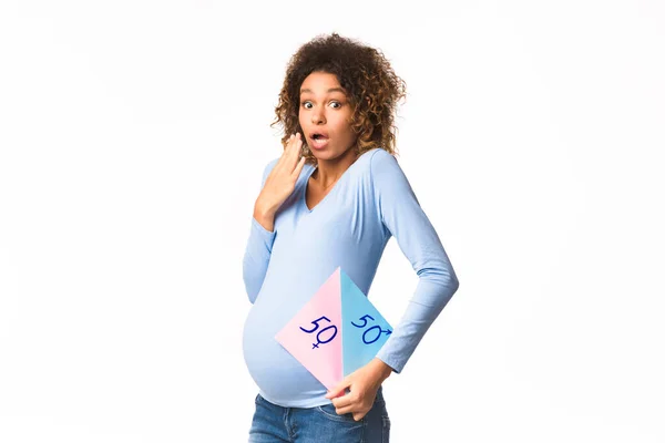 Mujer embarazada sorprendida sosteniendo papel con preguntas niño o niña —  Fotos de Stock