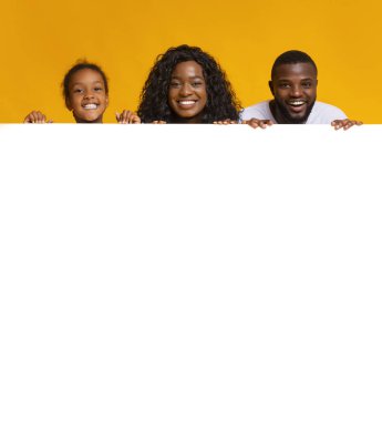 Siyah aile reklam için beyaz tahtaya yaslanıyor