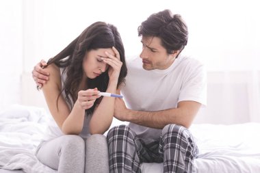 Üzgün bir adam, depresyondaki karısını negatif hamilelik testiyle rahatlatıyor.