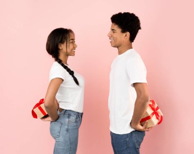 Arkalarında hediye kutuları taşıyan sevimli bir çift.