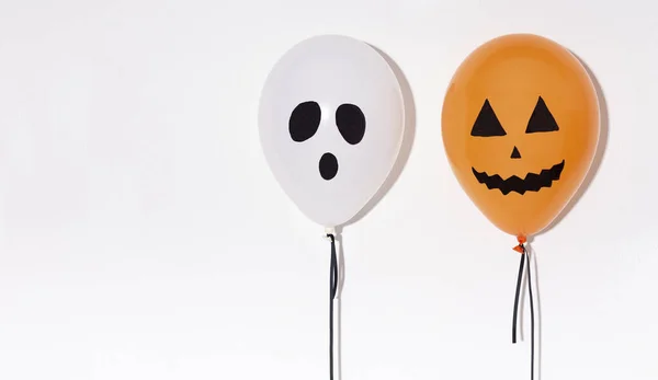 Dos globos de Halloween con caras divertidas aisladas en blanco —  Fotos de Stock