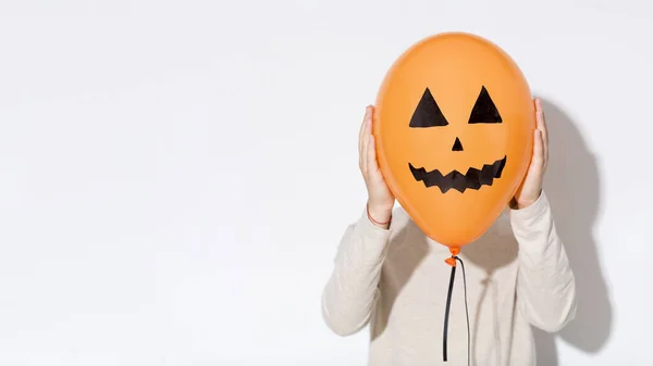 Mujer escondiendo su cara detrás de divertido globo de Halloween —  Fotos de Stock