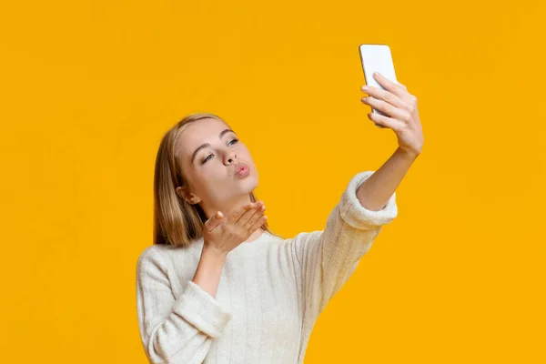 Coquette menina fazendo selfie no smartphone e enviar beijo de ar — Fotografia de Stock