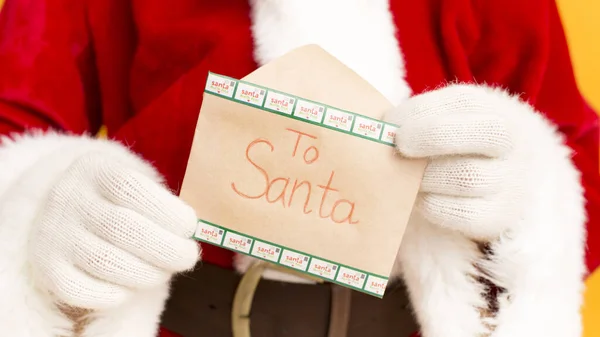 Papai Noel segurando carta desejo com texto nas mãos — Fotografia de Stock