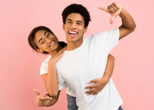 Casal alegre se divertindo e tirando foto na câmera imaginária — Fotografia de Stock