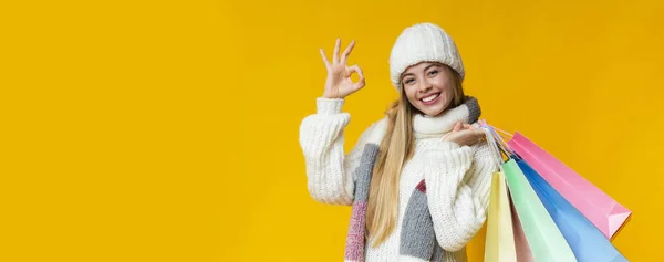 Belle fille en blanc hiver bonnet tricoté montrant signe ok — Photo