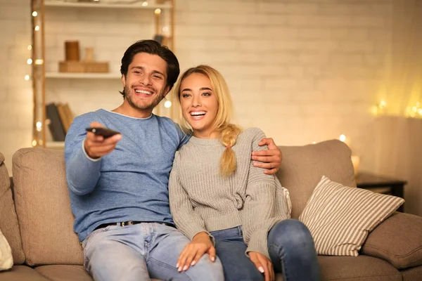 Šťastní manželé sledování televize na pohovce ve večerních hodinách — Stock fotografie