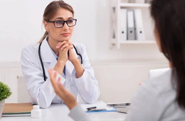 Ärztin hört Patientin zu, die sich über Gesundheit im Büro beschwert — Stockfoto