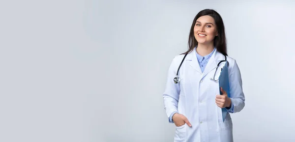 Självsäker läkare kvinna ler mot kameran stående, Studio skott, Panorama — Stockfoto