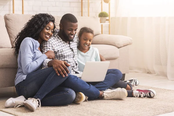 Far, mor och dotter använder laptop hemma tillsammans — Stockfoto