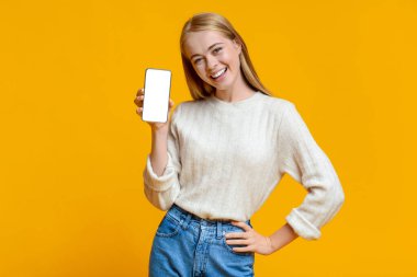 Güzel genç kız akıllı telefonu sunuyor boş ekranlı maket için.