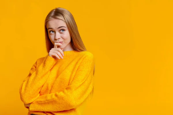 Portret van twijfelachtig tienermeisje over oranje achtergrond — Stockfoto