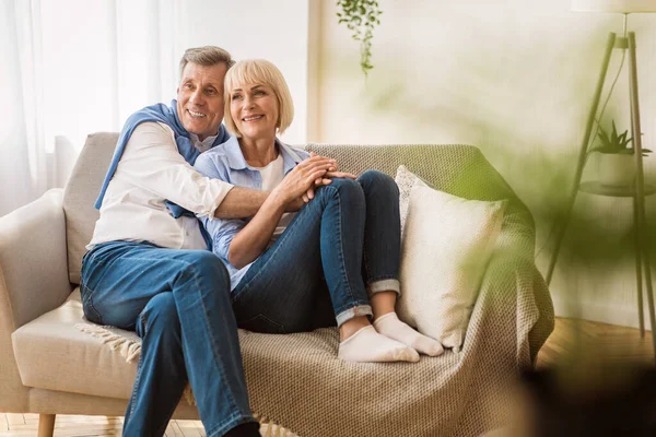 Romantic senior couple sitting close together on sofa — Stock Photo, Image