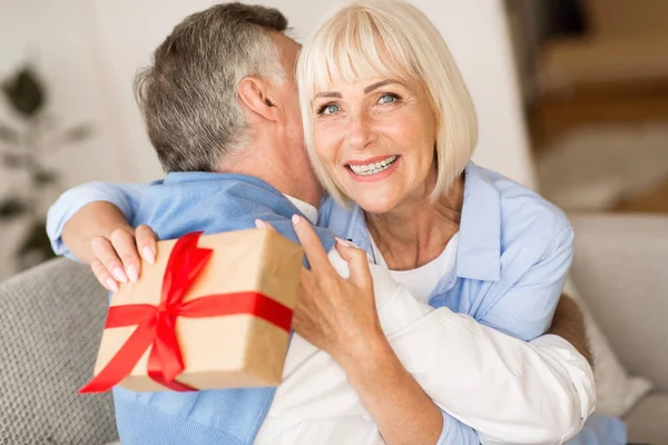 Подарок любви. Старшая женщина делает сюрприз мужу — стоковое фото