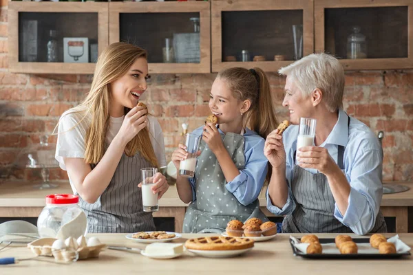 Női család élvezi a friss házi süteményt tejjel — Stock Fotó