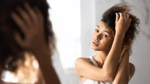 Afro Woman Touching Hair Looking In Mirror In Bathroom, Panorama — Stock Photo, Image