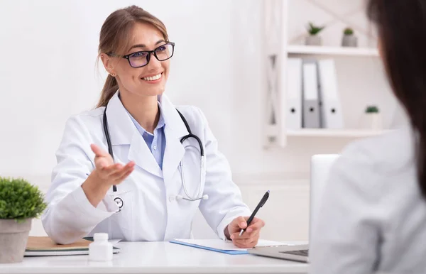 Fröhliche Ärztin im Gespräch mit Patientin schlägt Behandlung im Büro vor — Stockfoto
