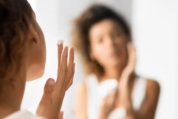 Jovem irreconhecível aplicando creme facial no banheiro — Fotografia de Stock