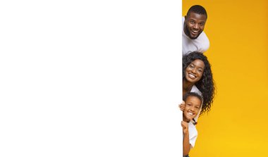 Anne-baba ve kız reklam için boş beyaz tahtadan dışarı bakıyorlar.