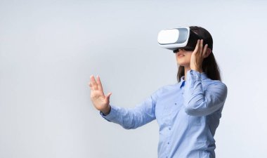 Vr Kulaklık kullanan genç bayan Gri Arkaplanda Duruyor