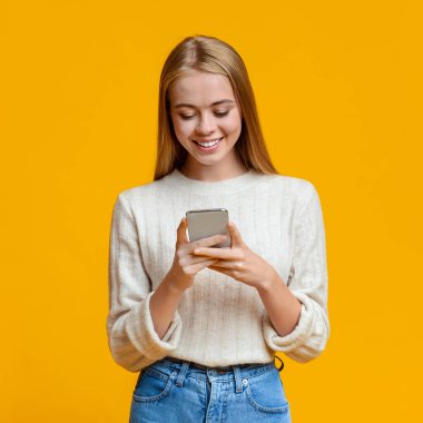 Turuncu Arkaplan Üzerinde Akıllı Telefondan Güzel Kız Mesajlaşması