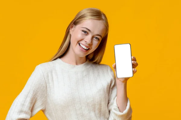 Smartphone con pantalla en blanco en manos de una niña milenaria sonriente — Foto de Stock