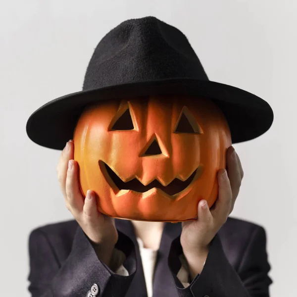 Hombre sosteniendo la cabeza de Jack o Lantern con sombrero negro sobre su cara —  Fotos de Stock