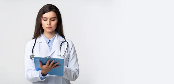 Ärztin hält Ordner mit Notizen im Stehen, Studio, Panorama — Stockfoto