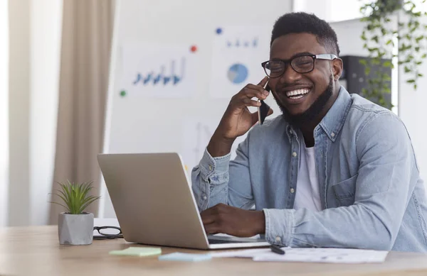Веселий підприємець говорить на мобільному телефоні під час роботи в офісі — стокове фото