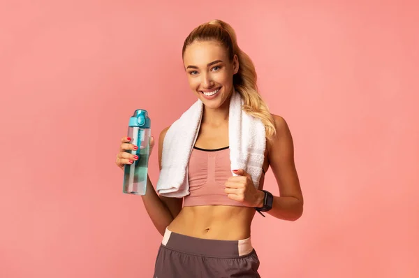 Smiling Girl Standing Holding Bottle of Water, Studio Shot — стоковое фото