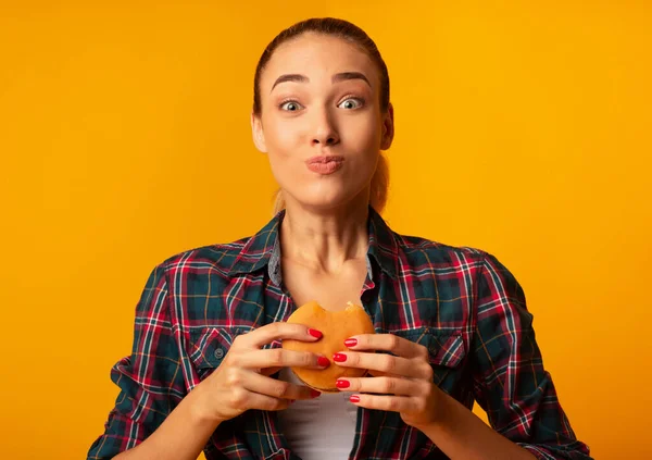 Burger Yiyen Kız Aldatan Yemek Sarı Arkaplanda Duruyor — Stok fotoğraf