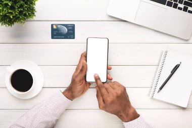 İş yerinde boş ekranlı akıllı telefon kullanan tanınmayan siyah çalışan.