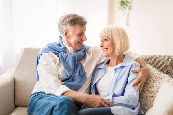 Щаслива старша пара дивиться один на одного, розслабляючись вдома — стокове фото