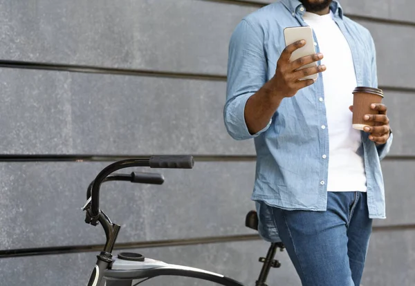 자전거를 타고 스마트폰을 사용하고 밖에서 커피를 마시는 무명의 남자 — 스톡 사진