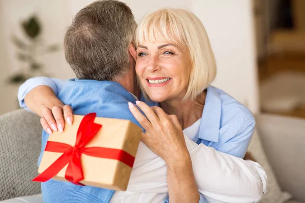 Счастливая жена обнимает мужа в подарок — стоковое фото