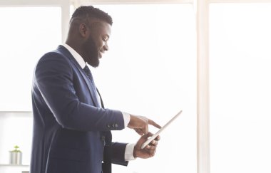 Genç ve neşeli girişimci iş için dijital tablet kullanıyor
