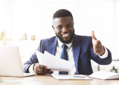 Genç siyahi işadamı tokalaşmak için elini uzatıyor