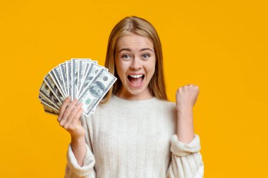Ecstatic teen girl rejoicing success and holding lots of cash clipart