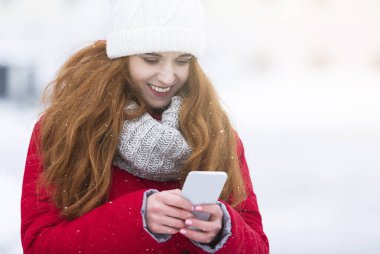 Neşeli genç kadın yürürken arkadaşlarıyla sohbet ediyor.