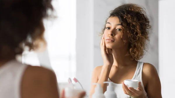 Pretty Black Girl Applying Face Cream Berdiri di kamar mandi, Panorama — Stok Foto