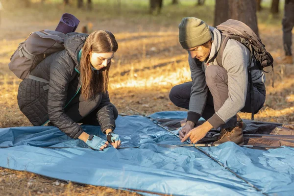 Guy et fille tangage tente, ayant pause dans la forêt d'automne — Photo