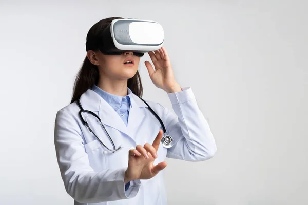 Doctor Woman Using Virtual Reality Headset Standing, Studio Shot