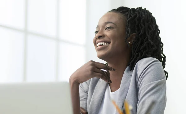 Zwart kantoor dame lachen zittend tegen raam op het werk — Stockfoto