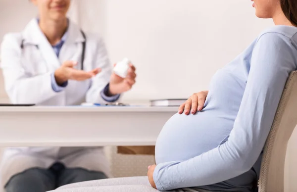 Lékař předepisuje pilulky pro těhotné pacientky v kanceláři — Stock fotografie
