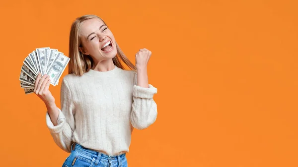 Joyful young girl holding bunch of money and rejoicing success — Stock Photo, Image