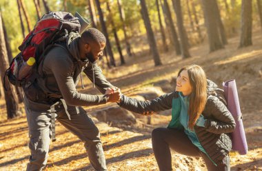 Zenci adam kız arkadaşının tırmanmasına yardım ediyor.