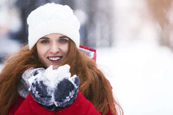 Retrato de una joven feliz sosteniendo la nieve en sus manos —  Fotos de Stock
