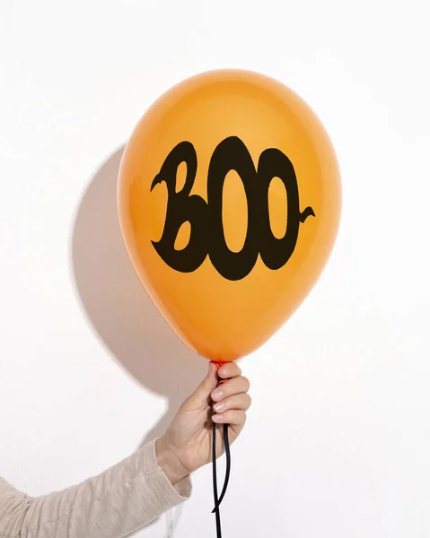 Woman holding Halloween balloon with boo creative text
