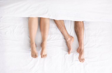 Yorganın altında, yatağa uzanmış birkaç milenyum bacağı.